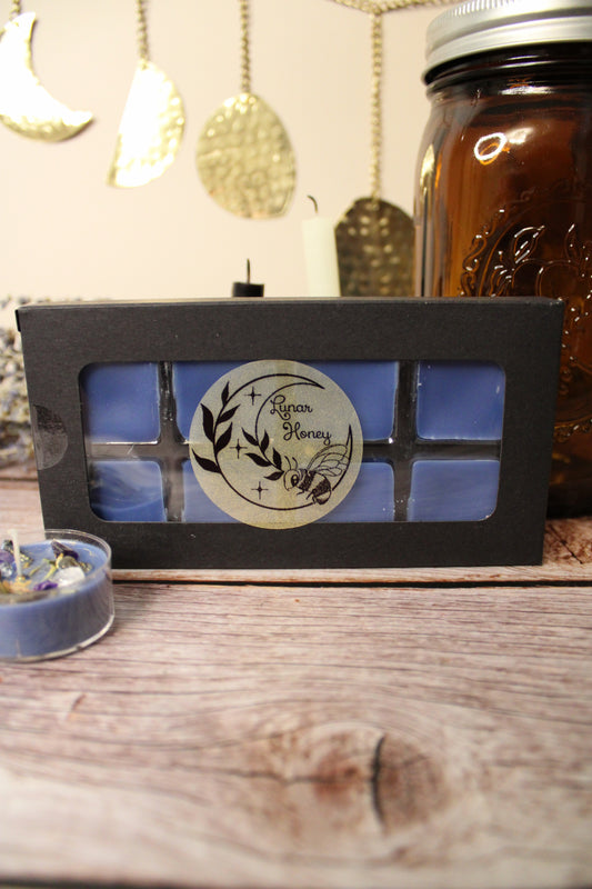 Candle in a black box with a blue wax on a wooden surface